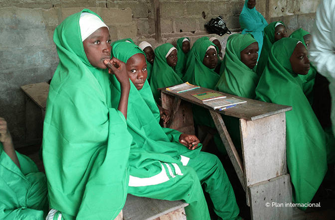 Girls sitting in school - Plan International